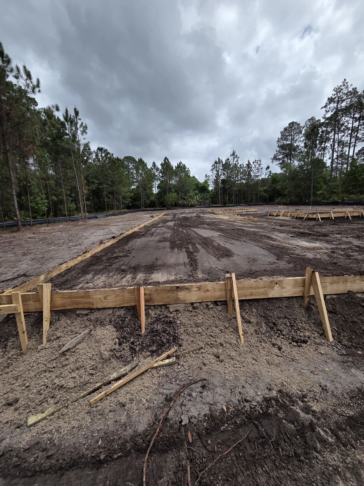 Mobile home pad preparation with grading and concrete forms in rural Florida